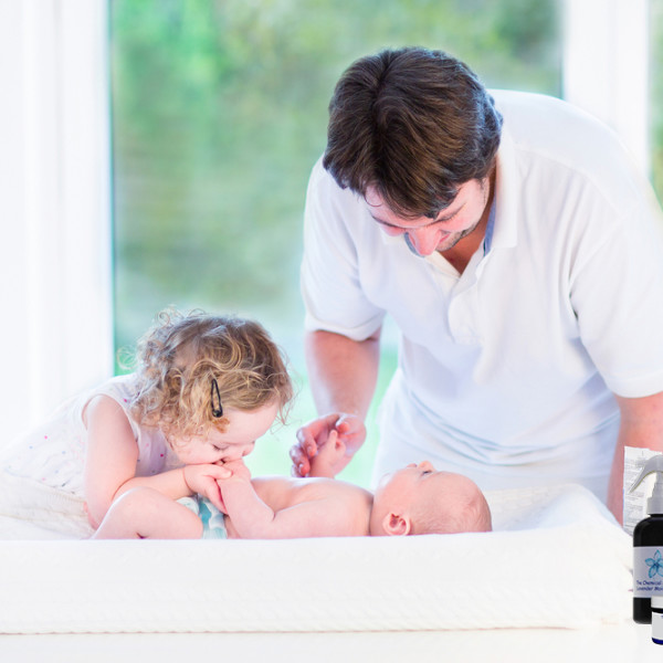 Dad and sister changing baby on changing table